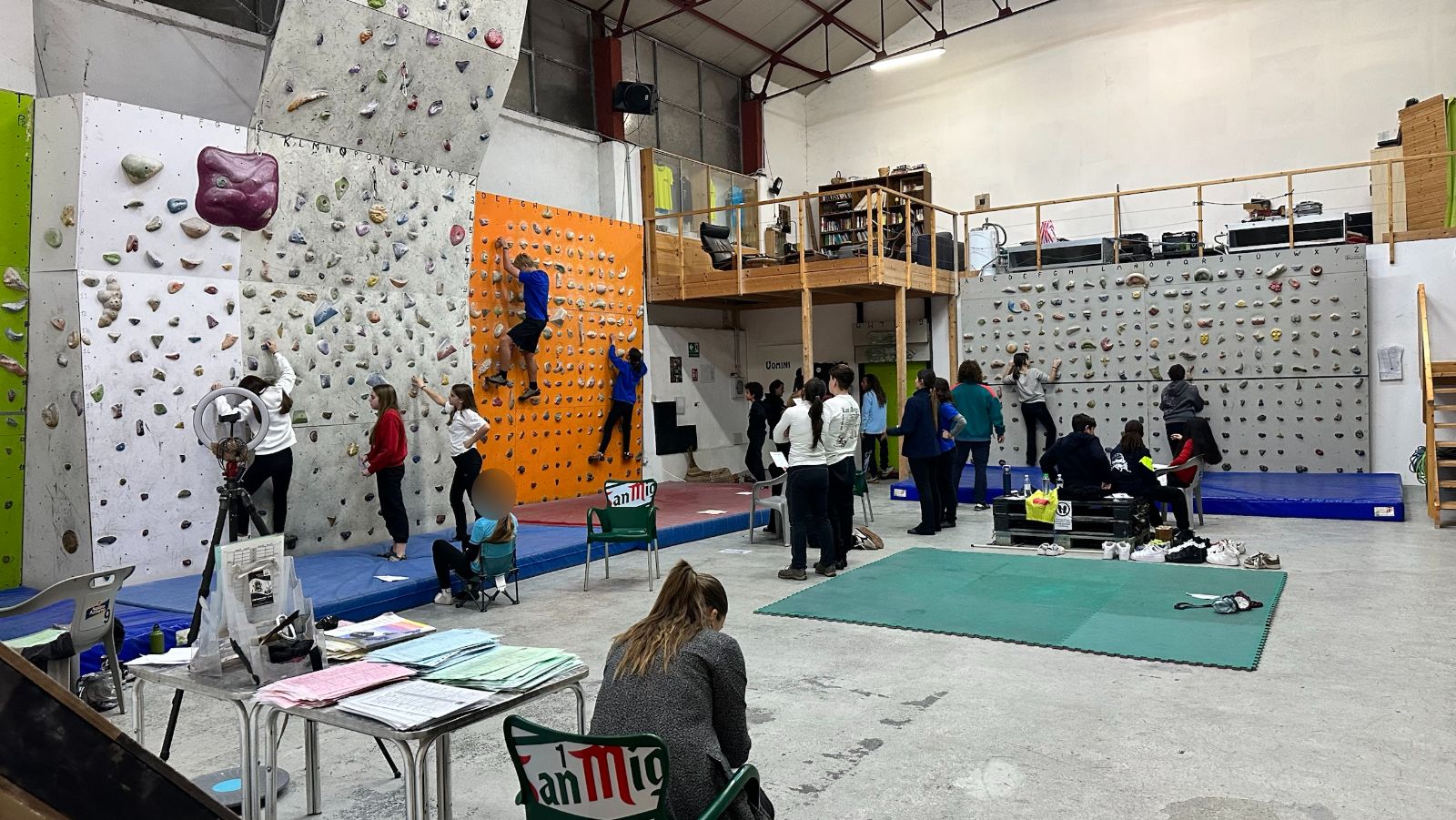La sala dell'Accademia RCC vista da lontano durante una lezione con una scuola: i ragazzi alle pareti con le schede di lavoro
